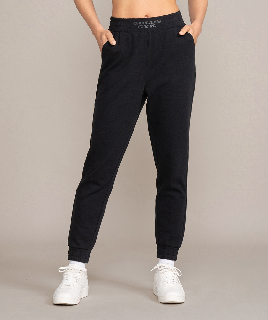 Black women's sweatpants from Gold's Gym. Tight-fitting long women's trousers with elasticated ribbed cuffs, front welt pockets and Gold's Gym lettering on the waistband.
